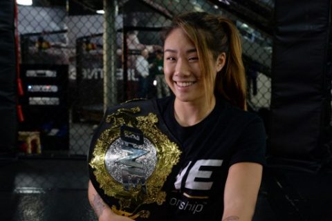 Singaporean mixed martial art fighter Angela Lee poses with her championship belt during an interview with AFP at a gym in Singapore on March 16, 2017. Top Asian fighter Angela Lee said on March 16 she is prepared to headline a "new era" for women's mixed martial arts in the region, and looked forward to a possible fight in China. / AFP PHOTO / ROSLAN RAHMAN