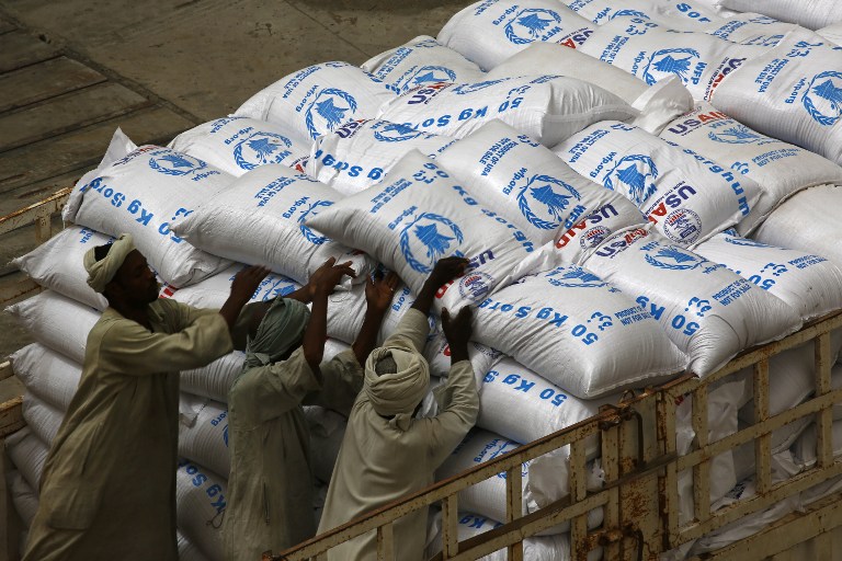 Sudanese workers offload US aid destined for South Sudan from the World Food Programme (WFP) at Port Sudan on March 19, 2017.   / AFP PHOTO / ASHRAF SHAZLY