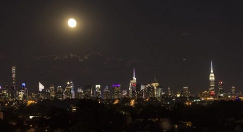 (FILES) This file photo taken on June 22, 2016 shows the moon rising above the Manhattan skyline in New York. For the eleventh year on March 25, 2017, cities will turn their lights off for the "Earth Hour" operation. However, progress still remains to be made to anchor this most important gesture for climate, wildlife and health into daily life. "Historically, lighting has been designed without taking the environment into account. In 2017, it is time to evolve", urge the defenders of the starry sky. / AFP PHOTO / OMAR TORRES