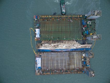 An aerial view shows the salvage operation of the Sewol ferry, off the coast of South Korea's southern island of Jindo on March 24, 2017. South Koreas sunken Sewol ferry emerged from the waters March 23, nearly three years after it went down with the loss of more than 300 lives and dealt a crushing blow to now-ousted president Park Geun-Hye. / AFP PHOTO / POOL / Lee Myung-Ik