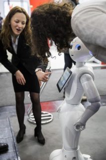 (FILES) This file photo taken on March 20, 2017 shows a robot interacting with visitors at the Soft Bank robotics stand at the Cebit technology fair in Hanover, Germany. Technology has long impacted the labor force, but recent advances in artificial intelligence and robotics have heightened concerns on automation replacing a growing number of occupations including highly skilled or "knowledge-based" jobs. / AFP PHOTO / Odd ANDERSEN / TO GO WITH AFP STORY by Rob LEVER, US IT lifestyle labor robots
