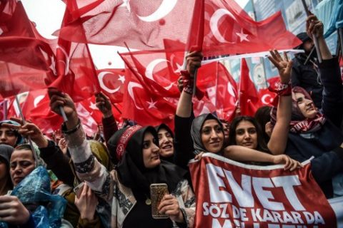 People wave national flags and cheer during a rally in support of the Turkish President on March 26, 2017 in Istanbul. Turkish President Recep Tayyip Erdogan on March 26 lashed out again in the diplomatic row with the European Union saying it would be "easier" if the EU just rejected Turkey's bid to join the bloc. / AFP PHOTO / OZAN KOSE