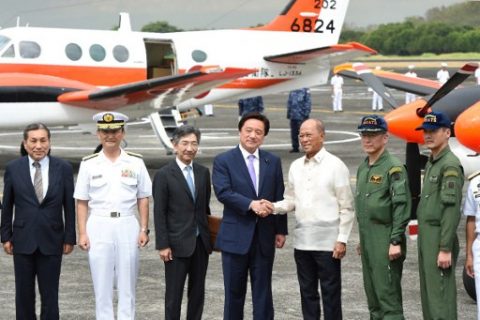 Philippine Defence Minister Delfin Lorenzana (3rd R) shakes hands with his Japanese counterpart Kenji Wakamiya (C) during a handover ceremony of two TC-90 training and maritime surveillance aircraft from the Japan Maritime Self-Defense Force to the Philippine Navy, at a naval base in Sangley point, Cavite province on March 27, 2017. / AFP PHOTO / TED ALJIBE
