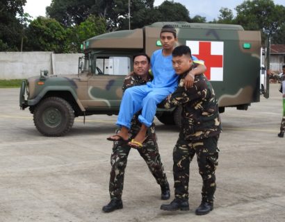 Filipino soldiers carry one of three rescued Malaysian hostages to a waiting aircraft at the airport in Jolo town, sulu province, in southern island of Mindanao on March 27, 2017. Three Malaysian seamen, kidnapped eight months ago by suspected Muslim extremists, were recovered by Philippine soldiers in the strife-torn south, the military chief said on March 27. / AFP PHOTO / NICKEE BUTLANGAN
