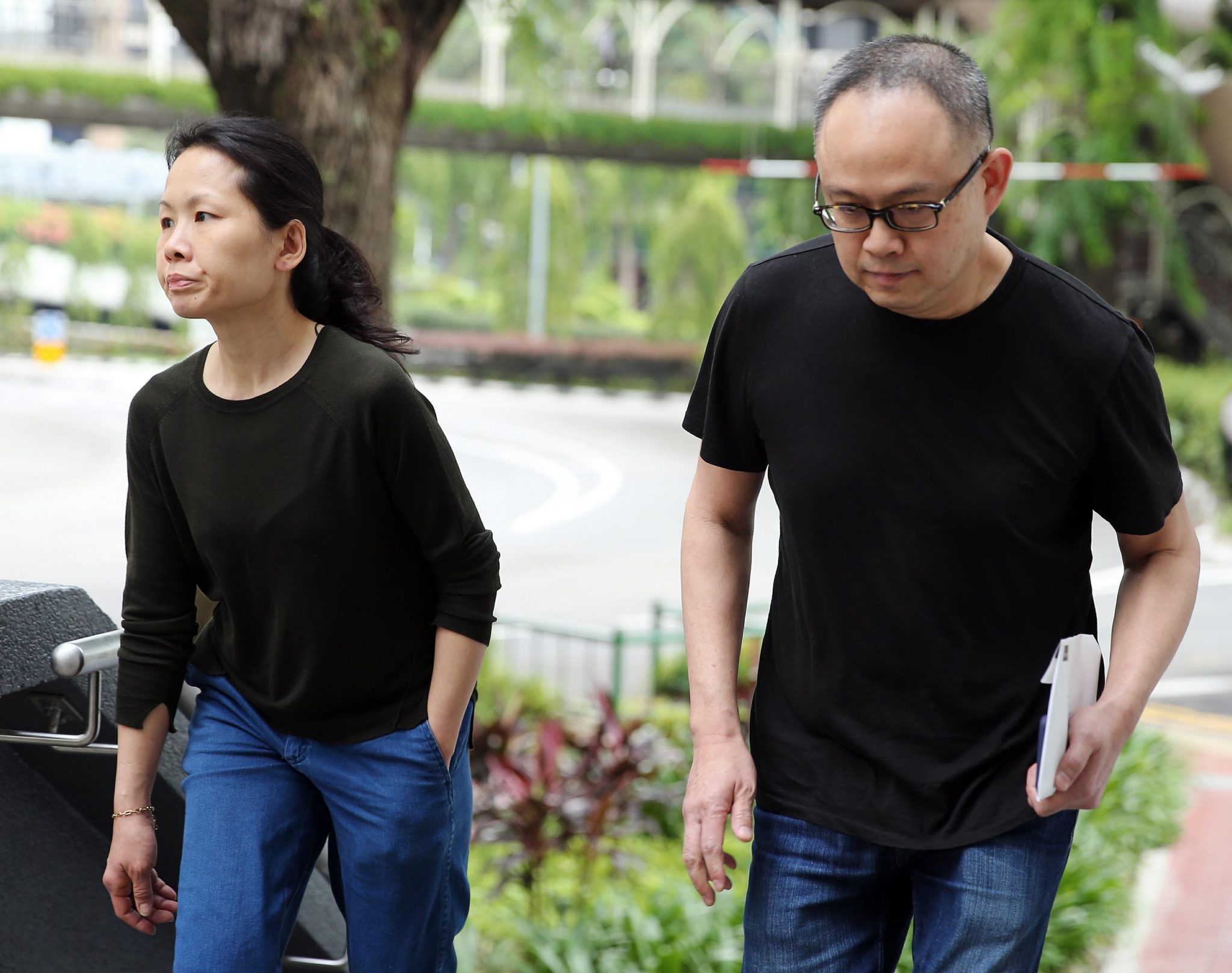 This photograph taken and released on March 27, 2017 by The Straits Times shows trader Lim Choon Hong (R) and his wife Chong Sui Foon (L) arriving at the state court in Singapore. A Singaporean couple, who starved their Philippine maid until her weight dropped to just 29 kilograms, were jailed, but state prosecutors asked for stiffer sentences. / AFP PHOTO / THE STRAITS TIMES / WONG KWAI CHOW / Singapore OUT / ---- EDITORS NOTE ----- RESTRICTED TO EDITORIAL USE MANDATORY CREDIT "AFP PHOTO / THE STRAITS TIMES / WONG KWAI CHOW" -- NO MARKETING -- NO ADVERTISING CAMPAIGNS - DISTRIBUTED AS A SERVICE TO CLIENTS -- NO ARCHIVES