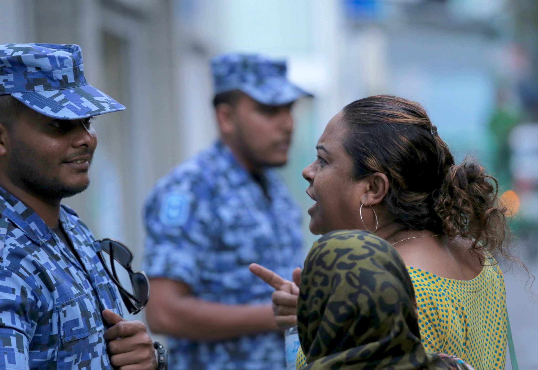 A Maldivian opposition activist argues with a policeman outside parliament in Male on March 27, 2017. Security forces physically ejected protesting MPs from the Maldives parliament March 27 in chaotic scenes during a failed opposition attempt to impeach the speaker and destabilise the president ahead of elections next year. Lawmakers shouted and stood on their chairs and one tried to physically remove the speaker's seat ahead of the impeachment vote, which came a day after exiled opposition leader Mohamed Nasheed announced a unity pact with the president's powerful half-brother -- the former strongman Maumoon Abdul Gayoom. / AFP PHOTO / STR