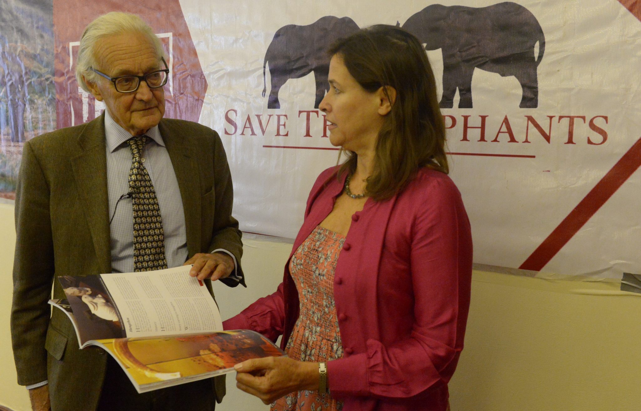 Iain Douglas -Hamilton, founder of Save The Elephants (STE) and leading authority on the African Elephant (L) accompanied by Lucy Vigne, Ivory researcher, look at a report documenting the decline of the wholesale price of raw ivory in China, on March 29, 2017 in Nairobi. / AFP PHOTO / SIMON MAINA