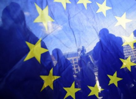 This picture taken through an EU flag shows people attending a pro-Europe demonstration in Berlin on March 26, 2017. Fed up with eurosceptics hogging the headlines and political debate, a growing number of Germans are going on the march to express their fervour for the European Union. / AFP PHOTO / Tobias SCHWARZ / TO GO WITH AFP STORY BY Daphne Rousseau