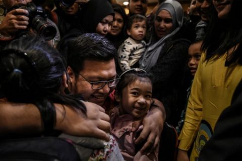 A family member hugs daughters of Mohd Nur Azrin Md Zin, Annur Zhafirah, 5, (R) and Annur Zulaikha, 6, (L) upon arriving at the Bunga Raya complex at Kuala Lumpur International Airport in Sepang early March 31, 2017 ending a bitter feud between the two countries following the murder of North Korean leader's half brother Kim Jong-Nam. Nine Malaysians freed by Pyongyang following a deal that ended a diplomatic crisis over the assassination of Kim Jong-Nam arrived home, a foreign ministry official and an AFP reporter said. / AFP PHOTO / MOHD RASFAN