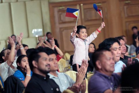 A young supporter waves small Philippine flags while President Rodrigo Duterte is talking on stage during a meeting with the Filipino community at the Horizon Lake View Hotel in Nay Pyi Taw, Myanmar on March 19, 2017. (Photo courtesy Presidential Communications facebook)