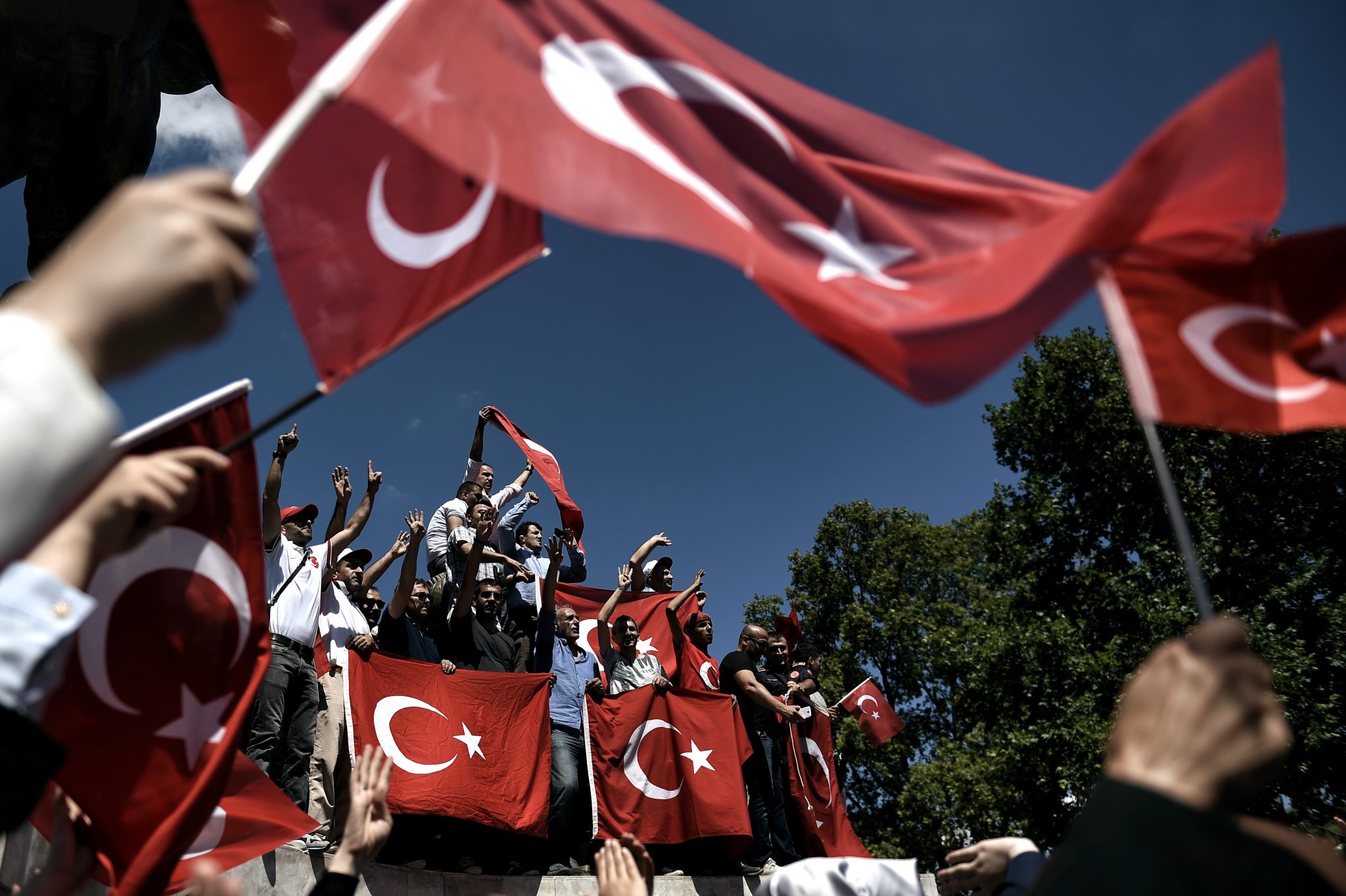 Pro-Erdogan supporters hold Turkish flags during a protest at the Sarachane park in Istanbul on July 19, 2016. The Turkish army said on July 19 that the vast majority of its members had no links with the July 15 attempted coup and warned that the putschists would face severe punishment. The armed forces blamed the "Fethullah Terrorist Organisation" (FETO) for the failed putsch, referring to Fethullah Gulen, a one-time ally turned foe of President Recep Tayyip Erdogan. Turkey's prime minister said on July 19 his government had sent four files to the United States, as Ankara seeks the extradition of US-based preacher Fethullah Gulen. / AFP PHOTO / ARIS MESSINIS