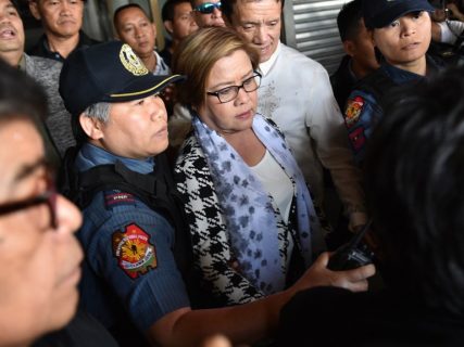 (File photo) Philippine Senator Leila De Lima (C), a top critic of President Rodrigo Duterte, is escorted by police officers and her lawyer Alex Padilla (R, in white long sleeves) after her arrest at the Senate in Manila on February 24, 2017. / AFP PHOTO / TED ALJIBE
