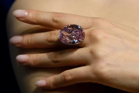 A model poses with a 59.60-carat oval mixed-cut pink diamond, known as 'The Pink Star', during a Sotheby's media preview in Hong Kong on March29, 2017, to promote its auction on April 4. A plum-sized pink diamond is expected to break the world record for a gemstone early next month when it goes under the hammer in Hong Kong, Sotheby's auction house. / AFP PHOTO / Anthony WALLACE