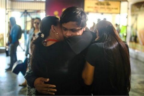 Filipino fisherman Rolando Omongos (C) 21 is hugged by his mother Rosalie (L) and another sibling, shortly after arriving at General Santos City airport, in southern island of Mindanao, on March 30, 2017. Omongos flew home to the Philippines on March 29 after being given up for dead at sea, battling hunger, thirst and despair for nearly two months on a tiny boat that drifted all the way to Papua New Guinea. / AFP PHOTO / FERDINANDH CABRERA