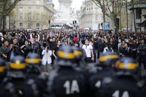 People face riot police as they take part in a demonstration on the Place de la Republique, in Paris, on April 2, 2017 to protest over the death of Liu Shaoyo, a 56-year-old Chinese man killed by police on March 26, 2017. The incident happened late on March 26 when police shot and killed a 56-year-old Chinese man named as Liu Shaoyo. Three officers were slightly injured in the incident and one police vehicle was damaged by an incendiary device. A police source told AFP that officers were called to the Chinese man's house after reports of a domestic dispute. / AFP PHOTO / Benjamin CREMEL