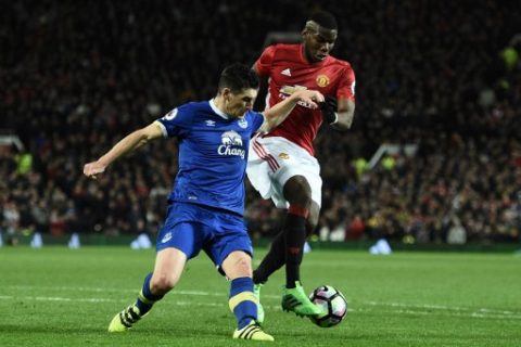 Everton's English midfielder Gareth Barry (L) vies with Manchester United's French midfielder Paul Pogba during the English Premier League football match between Manchester United and Everton at Old Trafford in Manchester, north west England, on April 4, 2017. / AFP PHOTO / Oli SCARFF / RESTRICTED TO EDITORIAL USE. No use with unauthorized audio, video, data, fixture lists, club/league logos or 'live' services. Online in-match use limited to 75 images, no video emulation. No use in betting, games or single club/league/player publications. /