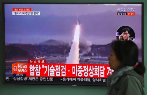 A woman walks past a television screen showing file footage of a North Korean missile launch, at a railway station in Seoul on April 5, 2017. Nuclear-armed North Korea fired a ballistic missile into the Sea of Japan on April 5, just ahead of a highly-anticipated China-US summit at which Pyongyangs accelerating atomic weapons programme is set to top the agenda. / AFP PHOTO / JUNG Yeon-Je