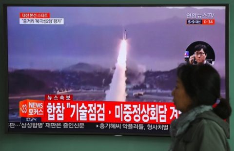 A woman walks past a television screen showing file footage of a North Korean missile launch, at a railway station in Seoul on April 5, 2017. Nuclear-armed North Korea fired a ballistic missile into the Sea of Japan on April 5, just ahead of a highly-anticipated China-US summit at which Pyongyangs accelerating atomic weapons programme is set to top the agenda. / AFP PHOTO / JUNG Yeon-Je