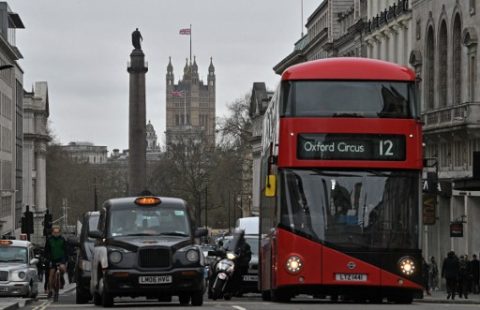 (FILES) This file photo taken on March 20, 2017 shows Union flags flying above and in front of Britain's Houses of Parliament as a black London taxi cab and red London bus wait at traffic lights in central London on March 20, 2017. London Mayor Sadiq Khan has declared war on London's air pollution announcing new charges to be imposed on the most polluting vehicles.  / AFP PHOTO / Justin TALLIS
