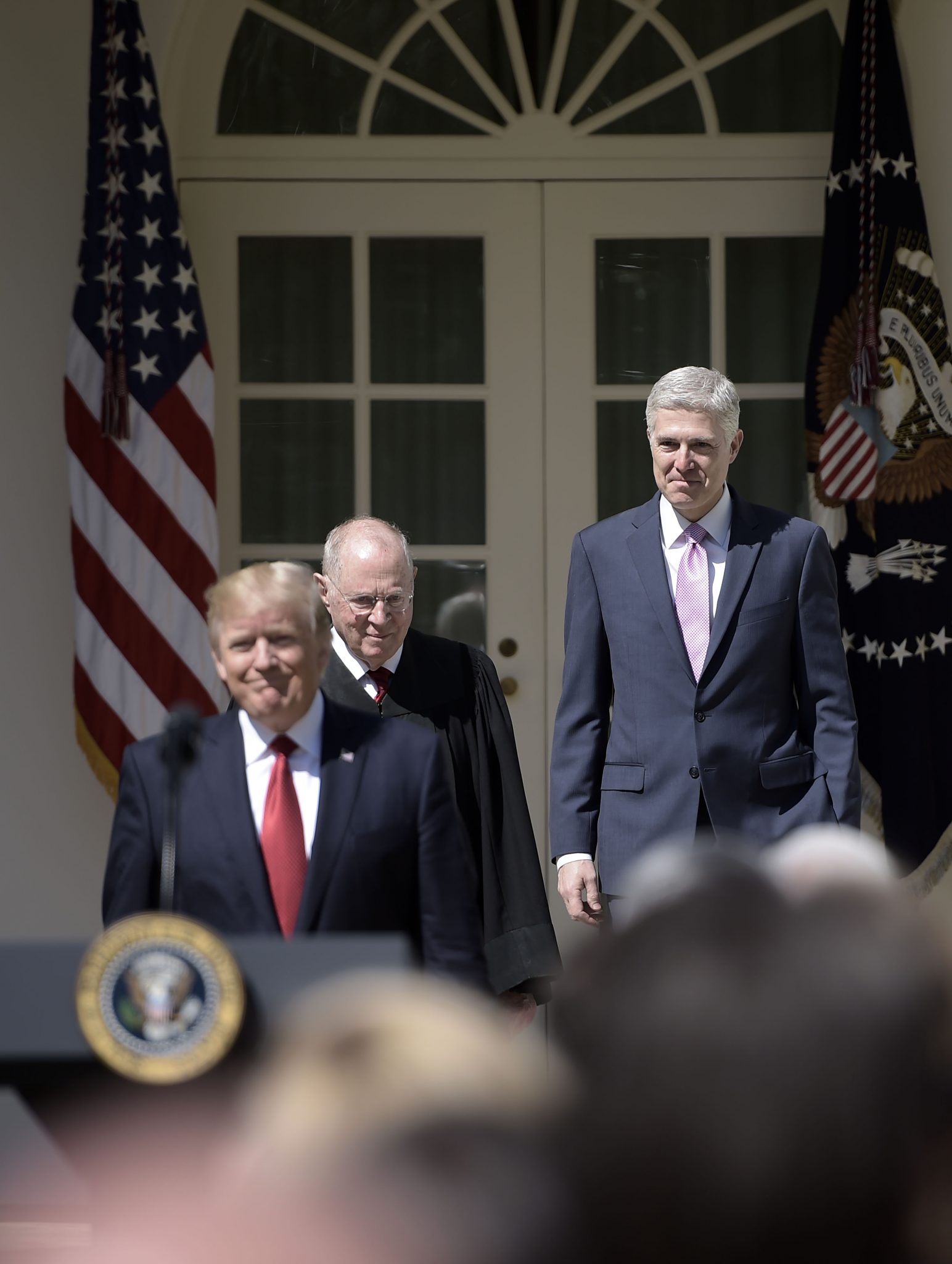 US President Donald Trump (L) arrives with Justice Anthony Kennedy (C) before Justice Kennedy administers the oath of office to Neil Gorsuch (R)as an associate justice of the US Supreme Court in the Rose Garden of the White House on April 10, 2017 in Washington, DC.   / AFP PHOTO / Brendan SMIALOWSKI