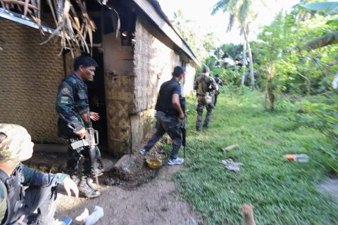 Police and soldiers take position as they engage with the Abu Sayyaf group in the village of Napo, Inabanga town, Bohol province, in the central Philippines on April 11, 2017. Nine people including four Philippine security officials were killed on April 11 during clashes with suspected Islamic militants on a popular resort island as millions prepare to travel for the Easter holiday. / AFP PHOTO / STR