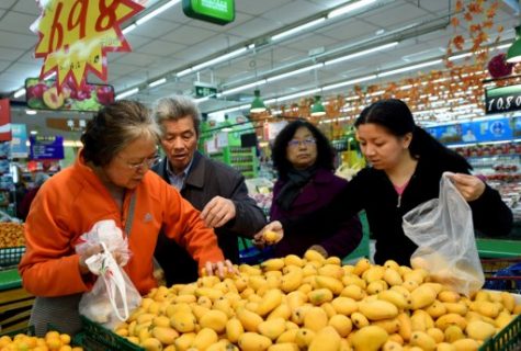Customers select mangos at a supermarket in Hangzhou, east China's Zhejiang province on April 12, 2017. Prices for goods at the factory gate in China jumped in March, the government said on April 12, in a positive sign of strengthening demand for the world's second-largest economy. / AFP PHOTO / STR / China OUT