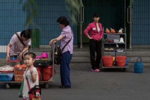 (FILES) This file photo taken on July 11, 2016 shows street vendors waiting for customers on the showcase 'Mirae Scientists Street' in Pyongyang. Economic change is quietly taking place in impoverished North Korea, even as authorities insist the philosophy of founder Kim Il-Sung remains their guide. / AFP PHOTO / Ed Jones / TO GO WITH NKorea-economy-politics,FOCUS by Sebastien Berger