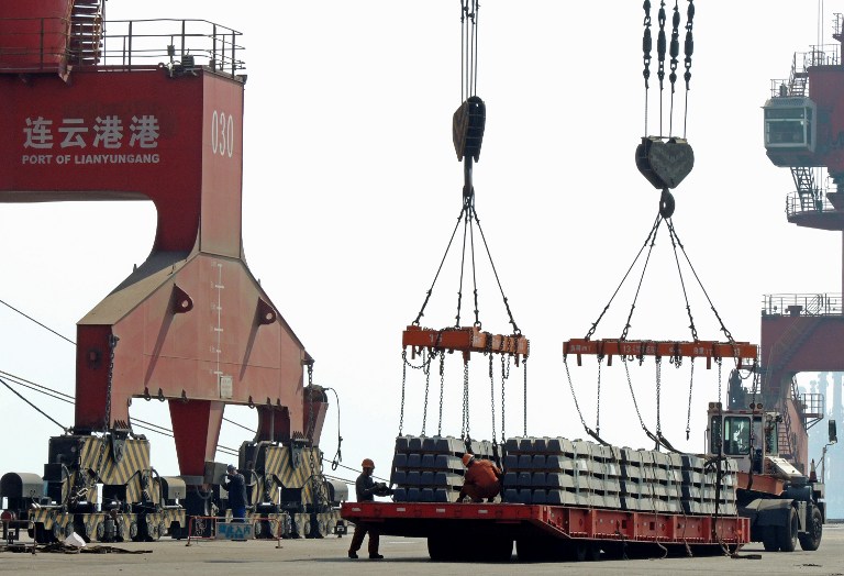 Chinese workers load goods for export at a port in Lianyungang, east China's Jiangsu province on April 13, 2017. Chinese exports surged 16.4 percent year-on-year to 180.6 billion USD in March, official data showed on April 13, in a sign of stabilisation for the world's second largest economy. / AFP PHOTO / STR / China OUT