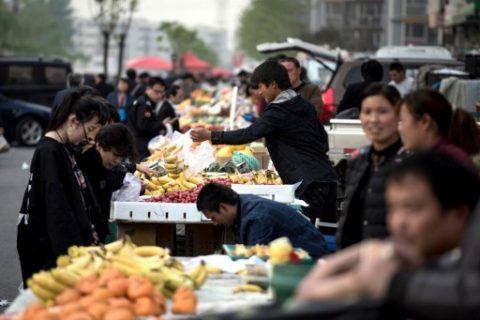 People buy vegetables at a market in Shunyi on the outskirts of Beijing on April 13, 2017. / AFP PHOTO / Fred DUFOUR