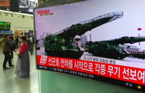 People walk past a television screen broadcasting live footage of a parade to mark the 105th anniversary of the birth of North Korea's founder Kim Il-Sung, at a railway station in Seoul on April 15, 2017. North Korean leader Kim Jong-Un on April 15 saluted as ranks of goose-stepping soldiers followed by tanks and other military hardware paraded in Pyongyang for a show of strength with tensions mounting over his nuclear ambitions. / AFP PHOTO / JUNG Yeon-Je