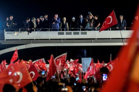 Turkish president Recep Tayyip Erdogan (C) delivers a speech to supporters in Istanbul, on April 16, 2017, after the results of a nationwide referendum that will determine Turkey's future destiny. Erdogan on April 16, 2017 hailed Turkey for making a "historic decision" as he claimed victory in the referendum on a new constitution expanding his powers. The "Yes" campaign to give Turkish President expanded powers won with 51.3 percent of the vote a tightly-contested referendum although the "No" camp had closed the gap, according to initial results. But Turkey's two main opposition parties said they would challenge the results. / AFP PHOTO / BULENT KILIC