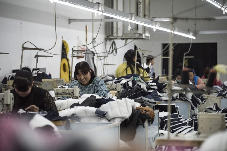 (FILES) This April 5, 2017 file photo shows workers at a textile factory in Anxin, in China's Hebei province. China's economy grew 6.9 percent in the first quarter of 2017, government data showed on April 17, beating expectations in the latest sign of stabilisation in the world's second-largest economy. / AFP PHOTO / FRED DUFOUR