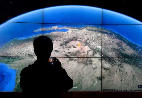 A man looks at a Google Earth map on a screen as Google Earth unveils the revamped version of the application April 18, 2017 at a event at New York's Whitney Museum of Art. Google on Tuesday launched a re-imagined version of its free Earth mapping service, weaving in storytelling and artificial intelligence and freeing it from apps. / AFP PHOTO / TIMOTHY A. CLARY