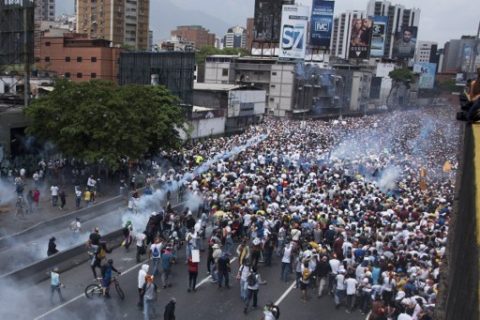 Demonstrators clash with riot police during a march against Venezuelan President Nicolas Maduro, in Caracas on April 19, 2017. Venezuelans took to the streets Wednesday for massive demonstrations for and against President Nicolas Maduro, whose push to tighten his grip on power has triggered deadly unrest that has escalated the country's political and economic crisis. / AFP PHOTO / CARLOS BECERRA