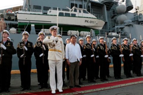 Philippines President Rodrigo Duterte (centre R) is welcomed by a Russian Navy honour guard during his visit to the guided missile cruiser Varyag of the Russian Navy's Pacific fleet at South Harbor in Manila on April 21, 2017. The Russian warship docked in Manila on April 20 in a visit aimed at boosting ties between the two countries as Duterte pivots his nation's foreign policy towards Moscow and Beijing. / AFP PHOTO / JOSEPH AGCAOILI