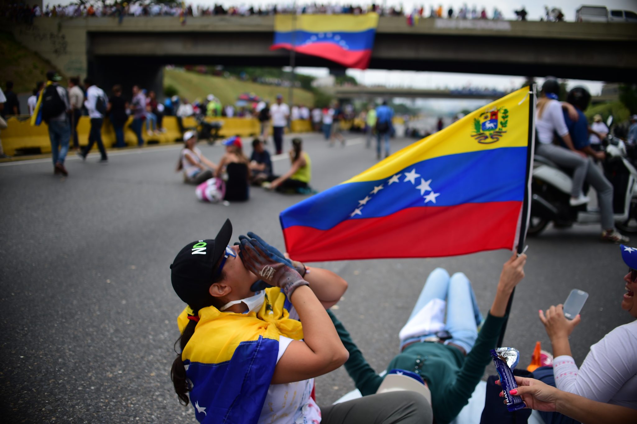 Venezuelan opposition activists organize a sit-in to block the Francisco Fajardo motorway in Caracas, on April 24, 2017. Protesters plan Monday to block Venezuela's main roads including the capital's biggest motorway, triggering fears of further violence after three weeks of unrest left 21 people dead. / AFP PHOTO / RONALDO SCHEMIDT