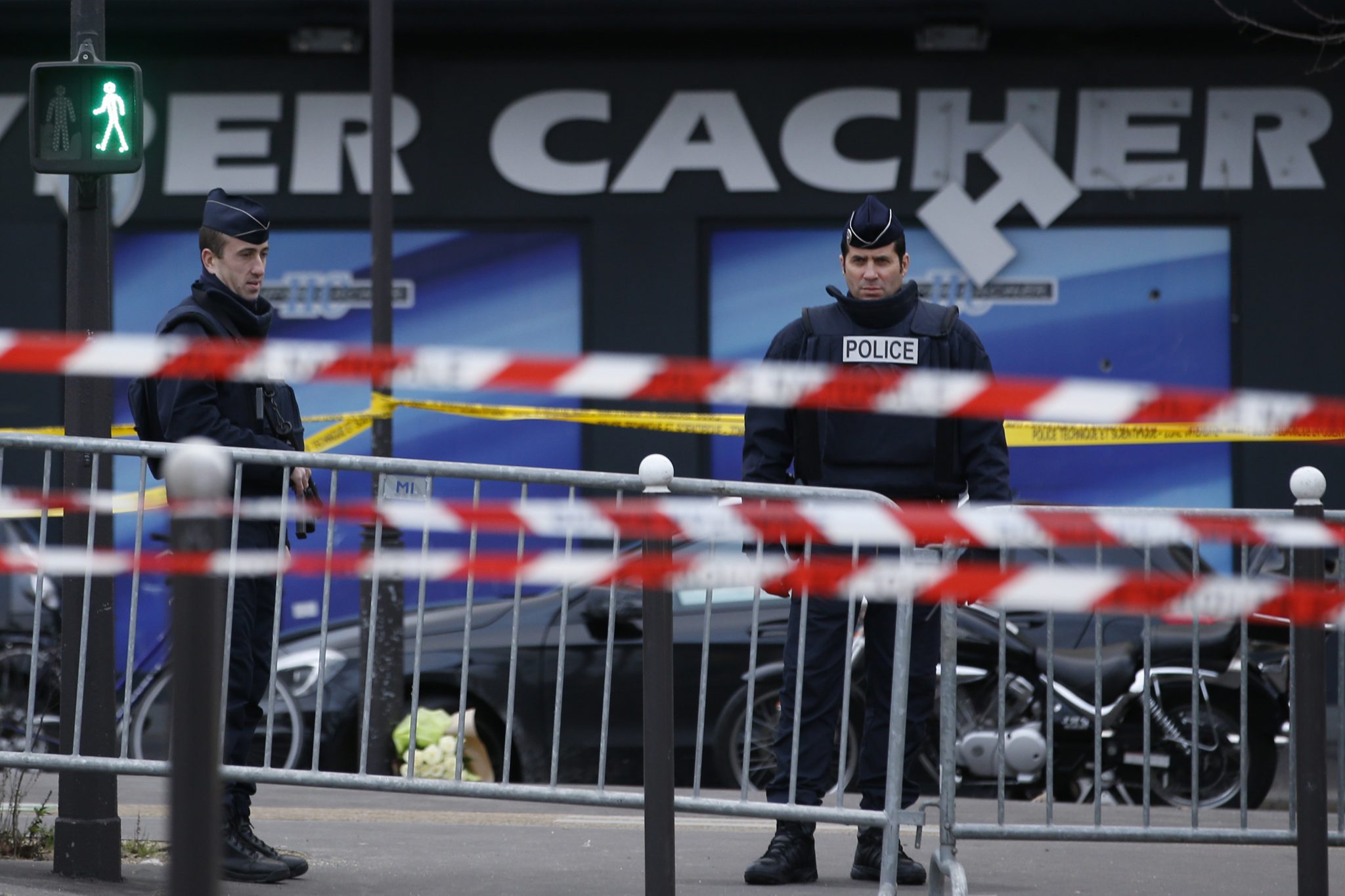 (FILES) This file photo taken on January 10, 2015 shows French police officers standing guard in front of a kosher grocery store in Porte de Vincennes, eastern Paris, a day after four people were killed at the Jewish supermarket by jihadist gunman Amedy Coulibaly during a hostage-taking.  Ten people have been held in custody since April 24, 2017 in connection with the investigation into the attacks in France on Charlie hebdo and Hyper Cacher in January 2015, suspected of involvement in the supply of weapons to Amedy Coulibaly, sources close to the investigation said on April 26, 2017.  / AFP PHOTO / KENZO TRIBOUILLARD