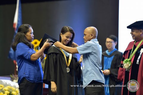 A proud father with his daughter, as he fixes up her medal while the mother waits on to put their daughter's graduation cap.  (Photo courtesy NEU official facebook page)