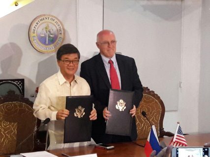Justice Secretary Vitaliano Aguirre and US Charge D'affaires Michael Klecheski sign the agreement to fight child trafficking on Tuesday. / Eagle News Service /Erwin Temperante/