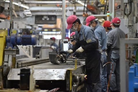 This photo taken on February 21, 2017 shows workers dismantling electric products at a Panasonic recycling factory in Inashiki, Ibaraki prefecture. The factory, which is implementing the idea of resources recycling, collects and processes end-of-life home appliances with the latest recycling technologies to recover materials for reuse or repurposing. / AFP PHOTO / Kazuhiro NOGI