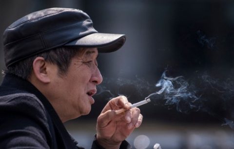 In this photo taken on February 28, 2017, a man smokes a cigarette on the streets in Shanghai. Shanghai widened its ban on public smoking March 1 as China's biggest city steps up efforts to stub out the massive health threat despite conflicts of interest with the state-owned tobacco industry. / AFP PHOTO / Johannes EISELE