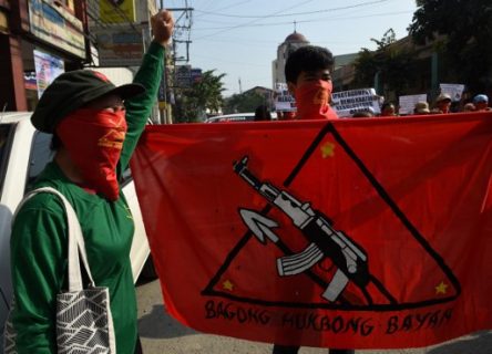 Members and supporters of the communist party of the Philippines' armed group, the New People's Army (NPA) shout slogans as they march toward the peace arch for a protest near Malacanang Palace in Manila on March 31, 2017. Fourth round of formal peace talks between the Philippine government and communist rebels are to be held in Oslo, Norway aimed at ending one of Asia's longest insurgencies. / AFP PHOTO / TED ALJIBE