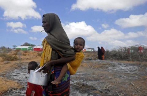 Newly displaced Somali women and children walk to a food distribution at the Kaxda district, outskirts of Mogadishu, on April 9, 2017. Somalia, a Horn of Africa country of 12 million people, is facing its third famine in 25 years of civil war and anarchy. At least 260,000 people died in the 2011 famine in Somalia -- half of them children under the age of five, according to the UN World Food Program. / AFP PHOTO / Mohamed ABDIWAHAB