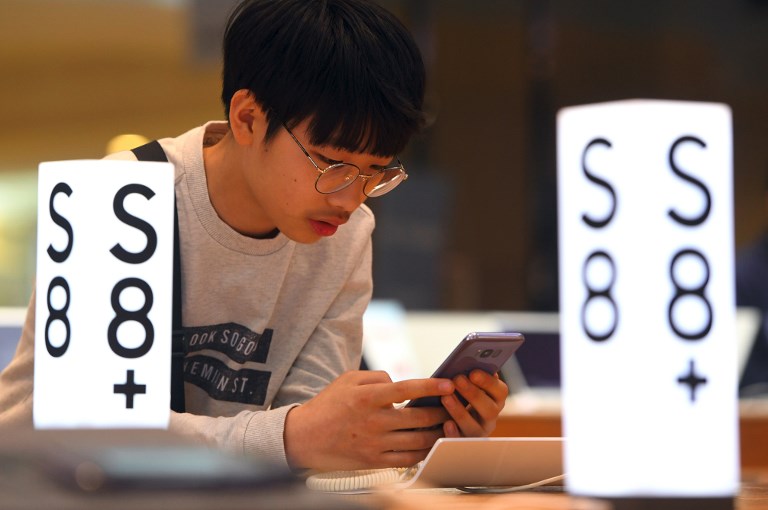 A man experiences the Samsung Galaxy S8 smartphone at the company's showroom in Seoul on April 27, 2017. South Korean tech giant Samsung Electronics posted its biggest quarterly net profit for more than three years on April 27 after shrugging off the fallout from the exploding Galaxy Note 7 battery debacle. / AFP PHOTO / JUNG Yeon-Je