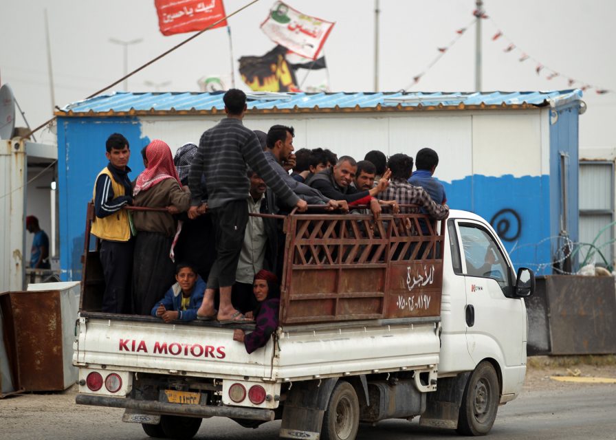Displaced Iraqis ride in a vehicle as they are evacuated from west Mosul on May 2, 2017, during the offensive to retake the city from Islamic State (IS) group fighters. / AFP PHOTO / AHMAD AL-RUBAYE