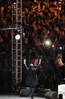 Supporters of French president-elect Emmanuel Macron waves to supporters as he arrives to deliver a speech at the Louvre Museum in Paris on May 7, 2017, after the second round of the French presidential election. Emmanuel Macron was elected French president on May 7, 2017 in a resounding victory over far-right Front National (FN - National Front) rival after a deeply divisive campaign. / AFP PHOTO / POOL / PHILIPPE LOPEZ