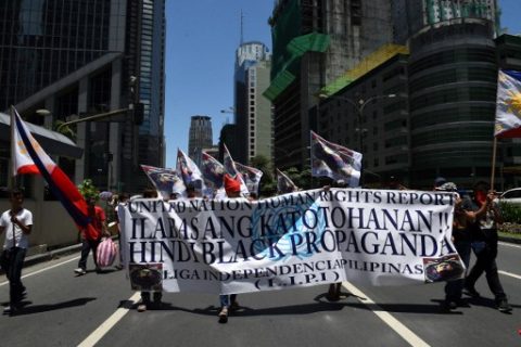 Pro-President Rodrigo Duterte protesters carry placards during a rally in front of the United Nations (UN) office in the financial district of Manila on May 8, 2017.  The protesters criticised United Nations' (UN) special rapporteur on extrajudicial killings, Agnes Callamard, as she made an unofficial visit to the Philippines on May 5, that angered President Rodrigo Duterte. / AFP PHOTO / TED ALJIBE