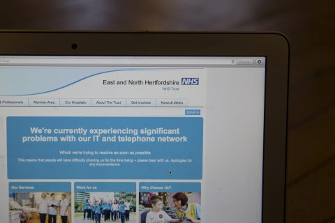 This photograph, posed as an illustration on May 12, 2017, shows the website of the NHS: East and North Hertfordshire notifying users of a problem in its network taken in London. The unprecedented global ransomware cyberattack has hit more than 200,000 victims in more than 150 countries, Europol executive director Rob Wainwright said May 14, 2017. Britain's state-run National Health Service was affected by the attack. / AFP PHOTO / Daniel LEAL-OLIVAS