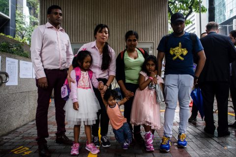 Sri Lankan refugee Ajith Puspa (back L), Filipino refugee Vanessa Rodel (back 2nd L), her daughter Keana (front L), Sri Lankan refugee Nadeeka (back 3rd L), her partner Supun Thilina Kellapatha and their children, son Danath (front C) and daughter Sethumdi (front R) pose for the press outside the Immigration Tower in Hong Kong on May 15, 2017. A group of refugees who sheltered fugitive whistleblower Edward Snowden in Hong Kong are facing deportation after the city's authorities rejected their bid for protection, their lawyer said on May 15. / AFP PHOTO / ANTHONY WALLACE