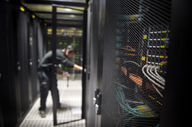 (FILES) This file photo taken on July 21, 2014 shows an employee of Equinix data center checking servers on July 21, 2014 in Pantin, a suburb north of Paris in the Seine-Saint-Denis department.   The world's biggest ransomware attack levelled off in Europe on May 15, 2017 hanks to a pushback by cyber security officials after causing havoc in 150 countries, as Microsoft urged governments to heed the "wake-up call". / AFP PHOTO / MARTIN BUREAU
